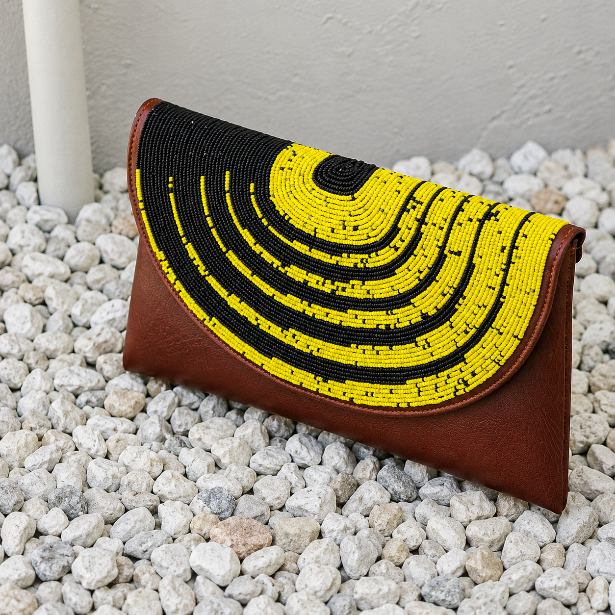 Close-up of the Imara handcrafted beaded leather clutch showcasing intricate black and yellow beadwork.