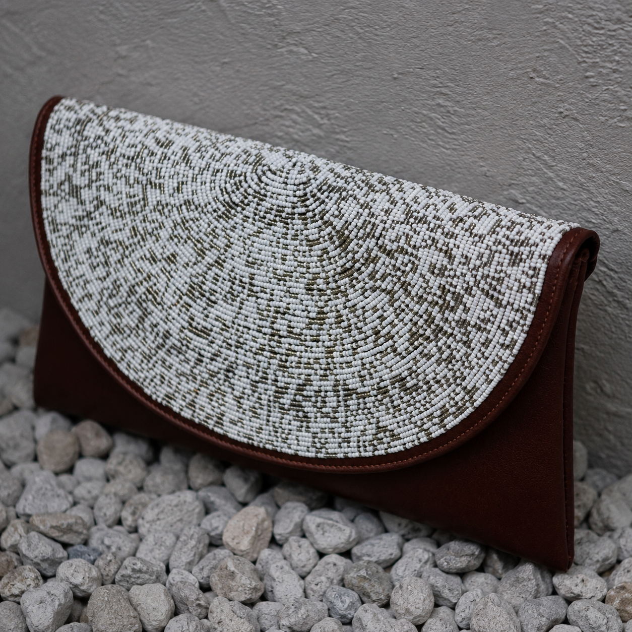 Close-up of the Nia handcrafted beaded leather clutch showcasing intricate white and grey beadwork.
